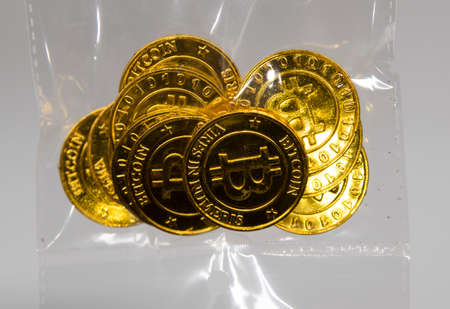 golden bitcoin coins in a plastic back,  representing the electronic currencyの写真素材
