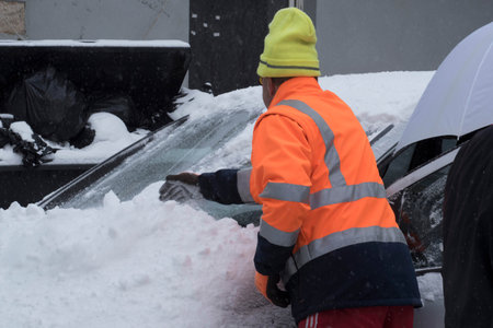 removing snow from the car, snow cleaning on a winter dayの写真素材