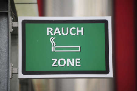a smoking area sign with a pictogram of a cigaretteの写真素材
