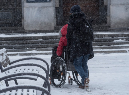transportation and mobility of a handicapped person in a wheelchair in winterの写真素材