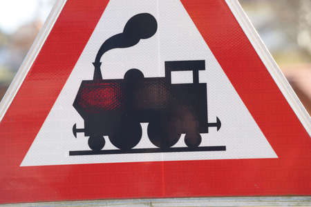 an ungated railroad crossing on the road, train traffic and transportationの写真素材