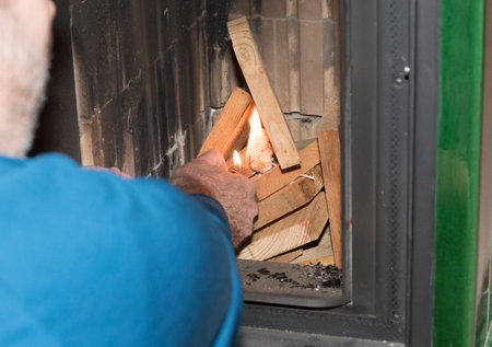 heating up a tiled stove, heating a room with woodの写真素材