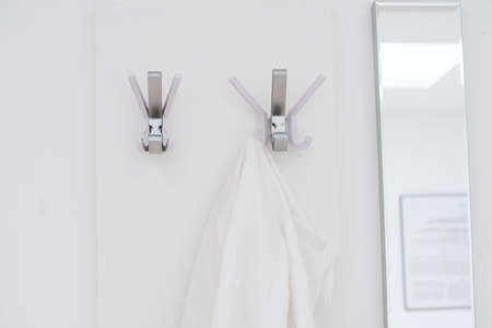 jackets from people hanging on coat hooks at the wardrobeの写真素材