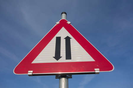 attention two way traffic or oncoming traffic road sign, red triangle as warning noticeの写真素材