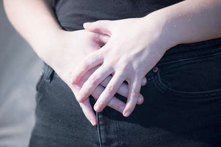 person with stomach ache or abdominal pain holding the painful areaの写真素材