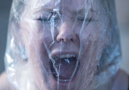 woman with bag over head symbolizing the feeling of claustrophobiaの写真素材