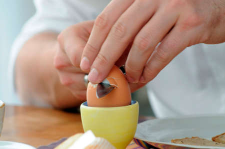 eating a breakfast egg for breakfast, opening an egg in an egg cupの写真素材