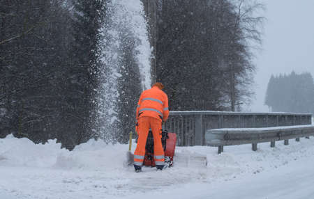 the removal of snow with a snow blower in winterの写真素材