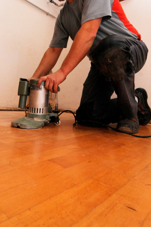 Craftsman sanding a parquet floor, working the floor in a buildingの写真素材