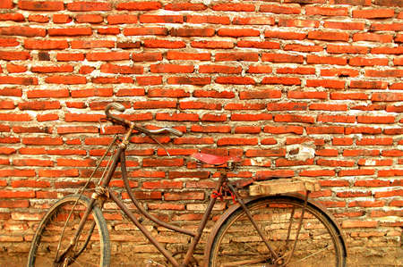 an old bicycle propped against the old wall wallの写真素材