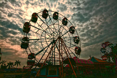 ferris wheel with dramatic sunset in backgroundのeditorial素材