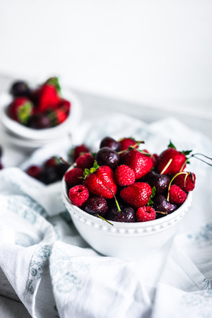 Mix of berries on white rustic backgroundの写真素材