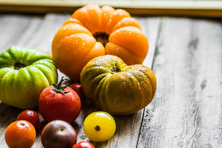 Colorful heirloom tomatoes on rustic wooden backgroundの写真素材