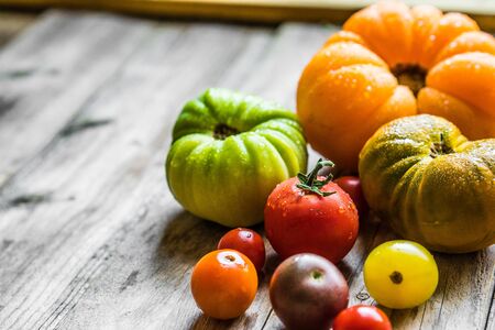 Colorful heirloom tomatoes on rustic wooden backgroundの写真素材