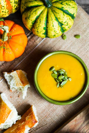 Creamy pumpkin soup with seeds on wooden backgroundの写真素材