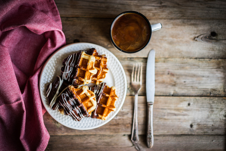Belgian waffles with chocolate on rustic wooden backgroundの写真素材
