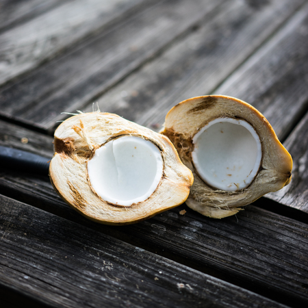 Halved coconut on wooden background