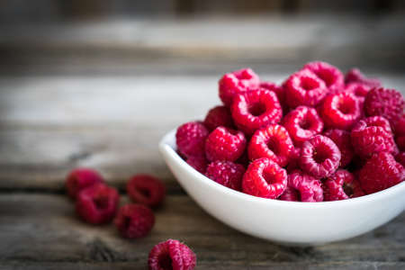 Fresh raspberries on rustic wooden background