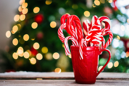 Candy canes in red mug on wooden backgroundの写真素材