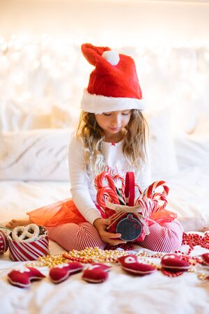 Cute baby girl in chritmas costume with candiesの写真素材