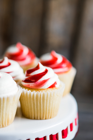 Strawberry and vanilla cupcakes on wooden backgroundの写真素材