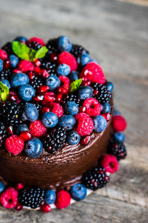 Chocolate cake with berries on wooden backgroundの写真素材
