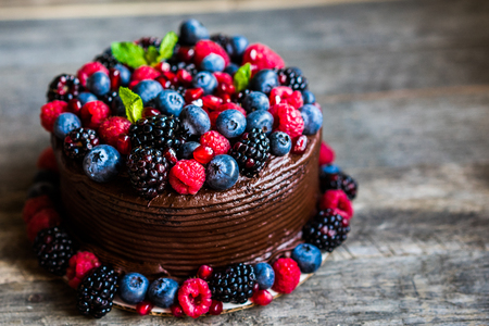 Chocolate cake with berries on wooden backgroundの写真素材