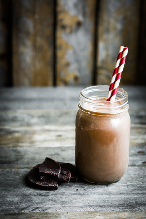 Chocolate milk in a jar on wooden backgroundの写真素材