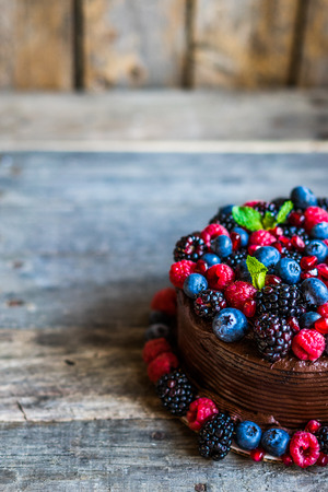 Chocolate cake with berries on wooden backgroundの写真素材