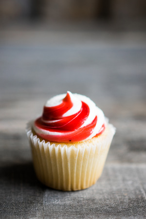 Strawberry and vanilla cupcakes on wooden backgroundの写真素材