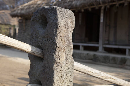 Traditional Korean door or gate with a removable wooden pole passing through an upright post with specially positioned holes that can be used to close off an openingの写真素材