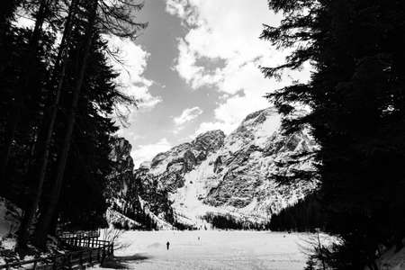Beautiful Italian landscape. Frozen Braies lake surrounded by high, snow-caped mountains in a sunny...