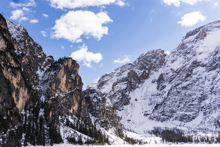 Beautiful Italian landscape. Frozen Braies lake surrounded by high, snow-caped mountains in a sunny...
