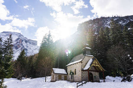 Beautiful Italian landscape. Frozen Braies lake surrounded by high, snow-caped mountains in a sunny winter day.の写真素材