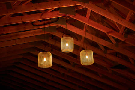 The luminaires are suspended from a wooden ceiling.の写真素材