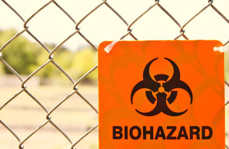 Biohazard sign attached to a chain link fence の写真素材
