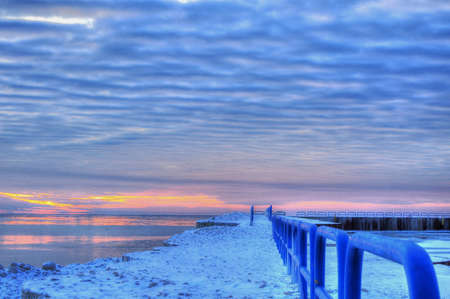 The End of the Earth  Sunrise on the horizon over an icy Lake Huron  Port Sanilac Harbor  Port Sanilac, Michigan の写真素材