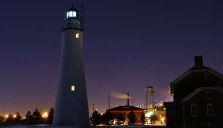 Lighthouse by the light of the full moon with downtown city lights as backdrop  Fort Gratiot Lighthouse  Lighthouse Park  Port Huron, Michigan の写真素材