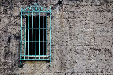 Window with decorative green grate set in the cement wall of a Moorish style castle  Huntington...