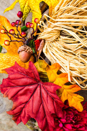Fall décor background, with acorn, berries, straw and leaves in vertical orientation  の写真素材