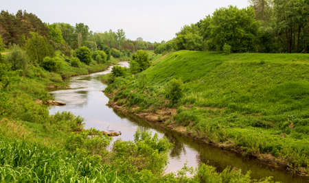 Peaceful Valley  A river winds through a lush green valley  の写真素材