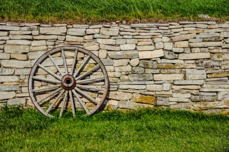 Wagon Wheel leaning against a century old stone wall  Fayette State Park  Garden, Peninsula  