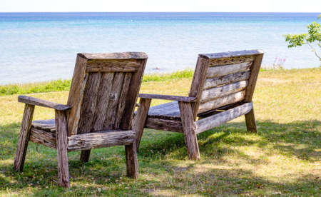 Wooden bench and outdoor seating in a park along the lakeshore  Forty Mile Point Lighthouse Park  Rogers City, Michigan  の写真素材