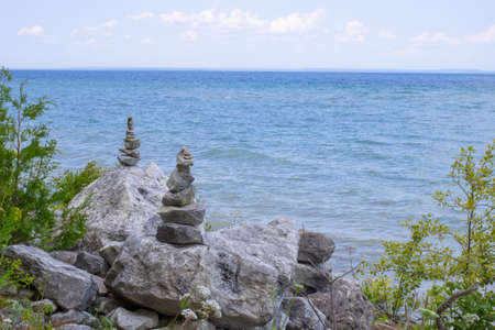 Zen rocks balanced on the edge of a watery horizon  の写真素材
