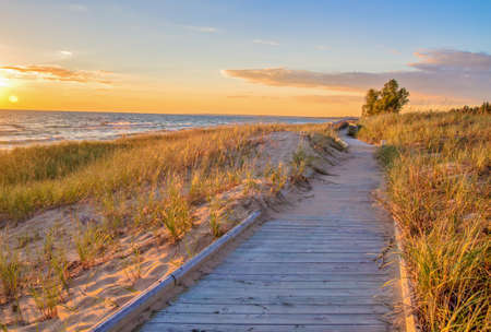 Boardwalk Beach. Wooden boardwalk along a coastal beach with a sunset horizon as the backdrop.の写真素材