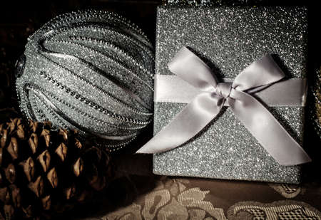 Silver gift box surrounded by elegant silver and gold decor.の写真素材