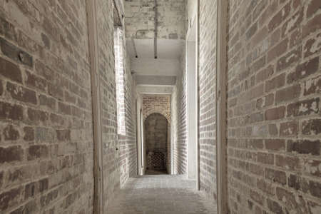 The Dark Passage. Narrow brick hallway with a dark exit at the end.の写真素材