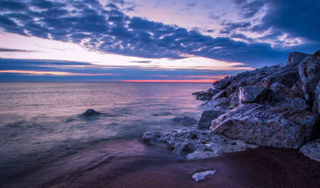 Lake Huron Sunrise. Wave crashes over the rocky Lake Huron coast. Tierney Park. Lexington, Michigan.の写真素材