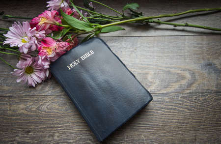 Christian Easter Holiday Background. Bouquet of spring flowers frame a King James Bible. Shot from...