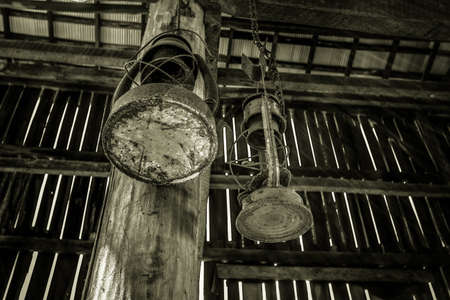 Rusted Antique Kerosene Lanterns. Rusted antique lanterns hang from the interior post in a barn.の写真素材